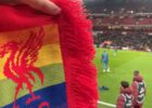 rainbow scarf in front of the pitch at anfield.