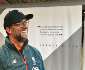 jurgen klopp with a black hat on smiling and looking off to the right with the words 'if you want special results, you have to feel special things and do things together. you can speak about spirit or you can live it' written next to him