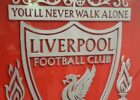 the liverpool crest in front of a shiny wall
