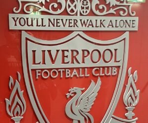 the liverpool crest in front of a shiny wall