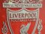 the liverpool crest in front of a shiny wall