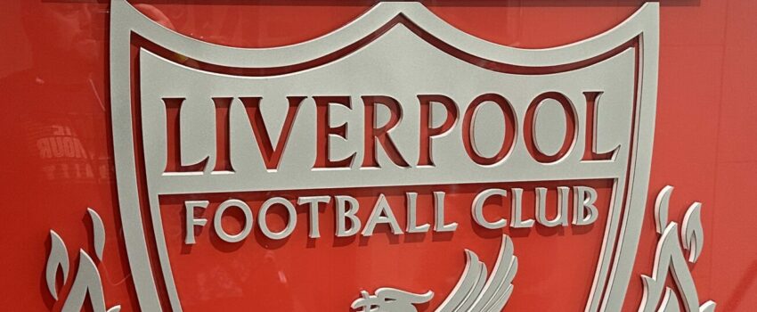 the liverpool crest in front of a shiny wall