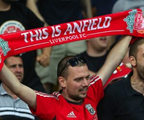 liverpool supporter holds up a red card saying this is anfield