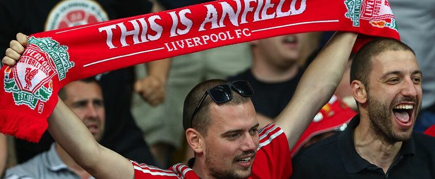 liverpool supporter holds up a red card saying this is anfield