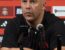 arne slot in a black liverpool training top in front of some microphones