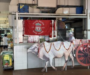 a liverpool flag in front of a cow inside a market in singapore