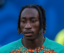 yan diomande wearing an ivory coast training top in front of a blue background